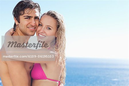 Side view of happy couple embracing in the pool