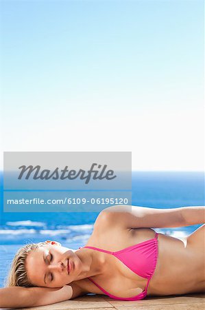 Woman enjoying sunny day on the pool edge