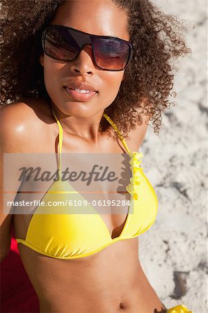 Jeune femme séduisante dans Boardshorts lunettes de soleil tout en réfléchissant
