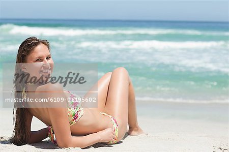 Woman looking over her shoulder while sunbathing