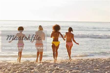 Four women running into the water