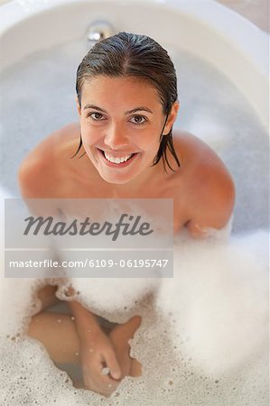 Lächelnde Frau in der Wanne, Blick nach oben Lächelnde Frau in der Wanne, Blick nach oben