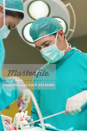 Blick auf eine ernsthafte Chirurgen halten Operationsinstrumente