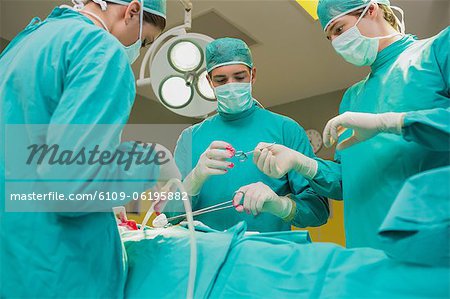 Vue d'un infirmier donnant un ciseaux à un chirurgien