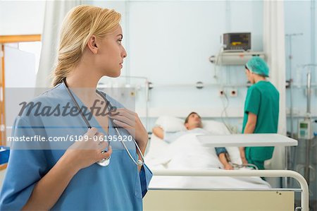 Blonde nurse touching her stethoscope