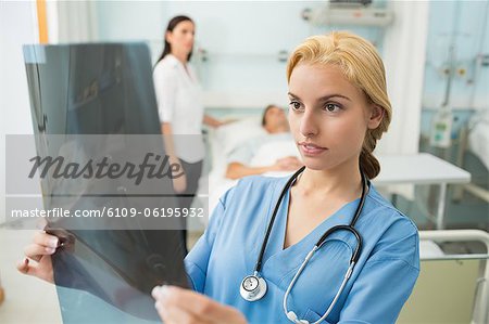 Infirmière blonde en regardant une radiographie