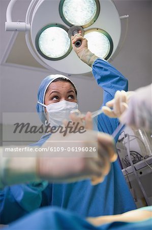 Équipe de chirurgie sous des lampes chirurgicales