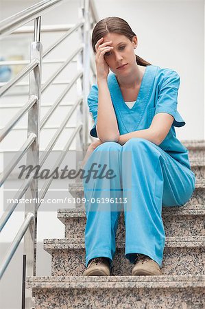 Thinking woman sitting on stairs