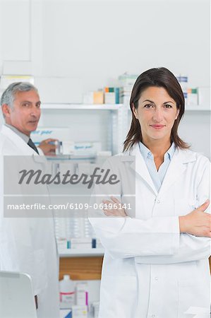 Pharmaciens de femme avec son bras croisés et un collègue