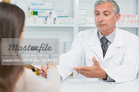 Pharmacist giving pills to a customer