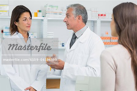 Pharmacist talking to a colleague in front of a client