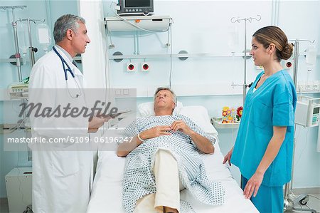 Nurse and doctor talking in the room of a patient