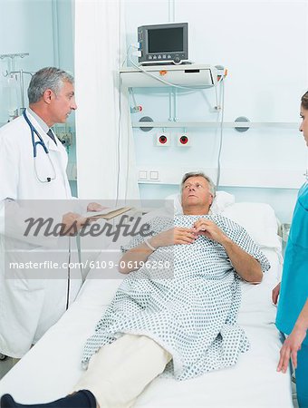 Médecin et une infirmière avec un patient dans un service de chambre