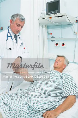 Doctor measuring the pulse of a male patient