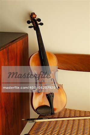 Violin leaning against rope chair