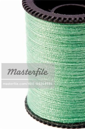 Close-up photograph of green thread spool on a white background.