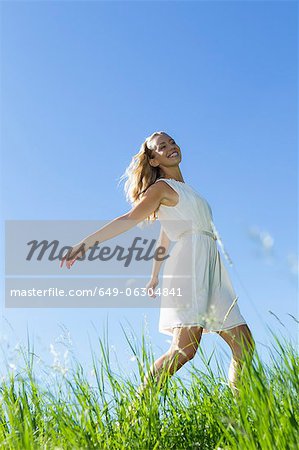 Smiling woman walking in tall grass
