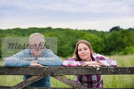 Father and daughter on wooden fence