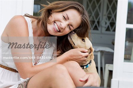 Femme souriante, jouant avec le chien