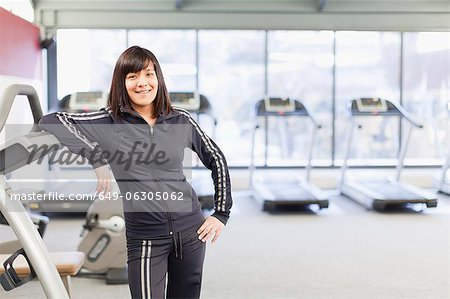 Woman leaning on Laufband im Fitness-Studio