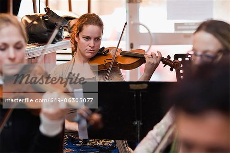 Geigenspieler üben mit Gruppe