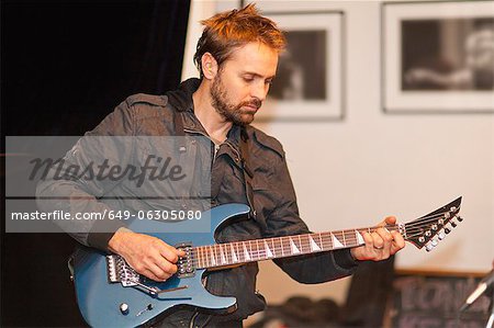 Guitar player practicing indoors
