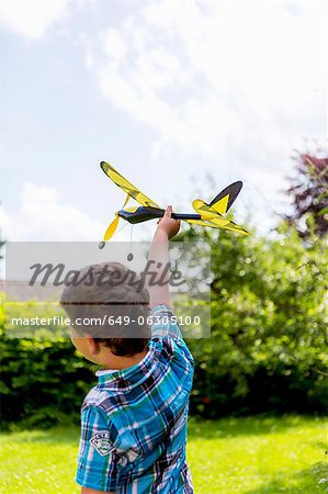 Jungen spielen mit Spielzeugflugzeug im freien