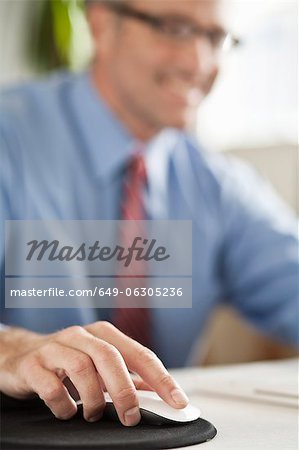 Businessman clicking mouse at desk