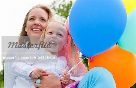Mother and daughter holding balloons