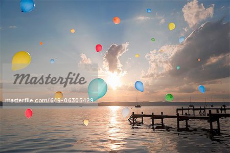 Balloons floating over still lake