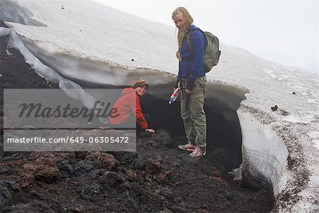 Mother and daughter exploring snow drift