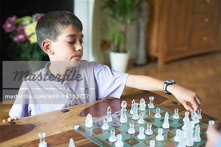 Boy playing chess in living room