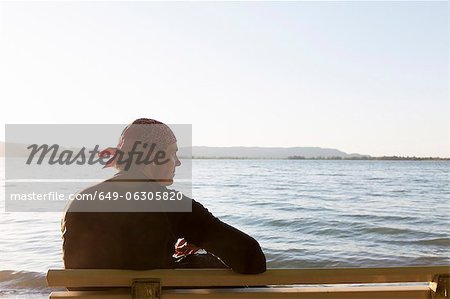 Homme assis sur un banc à la plage