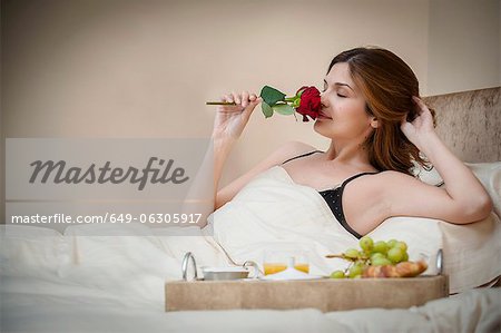 Woman relaxing with breakfast in bed Woman relaxing with breakfast in bed