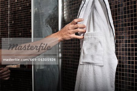 Homme de peignoir de bain dans la douche