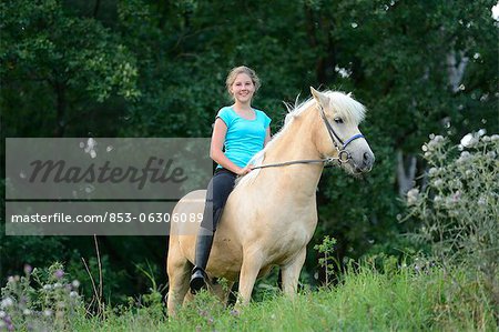 Smiling girl riding on horse