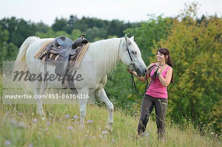 Lächelnd Teenager-Mädchen mit Pferd auf der Wiese