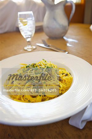 Spaghetti mit Kapern in einer Butter-Knoblauch-Sauce; In einer Schüssel weiß