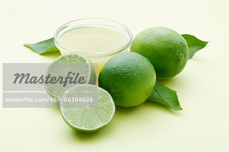 Eine Schale mit Limettensaft und frische Limetten