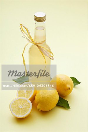 Eine Flasche Limonade und frische Zitronen