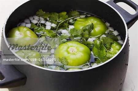 Tomatillos, Zwiebeln und Koriander Einweichen in einem Topf