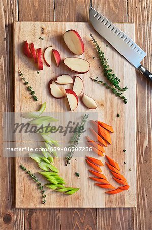 Pommes de terre rouges hachés, de carottes et de céleri au thym sur une planche à découper ; D'en haut Pommes de terre rouges hachés, de carottes et de céleri au thym sur une planche à découper ; D'en haut