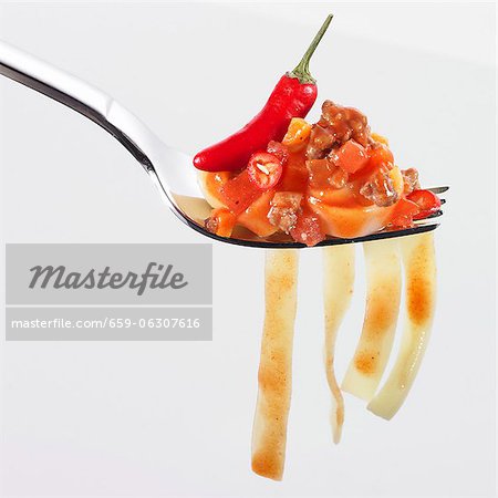 Tagliatelle, tomate épicée et viande hachée sauce piri-piri et le piment sur une fourche Tagliatelle, tomate épicée et viande hachée sauce piri-piri et le piment sur une fourche