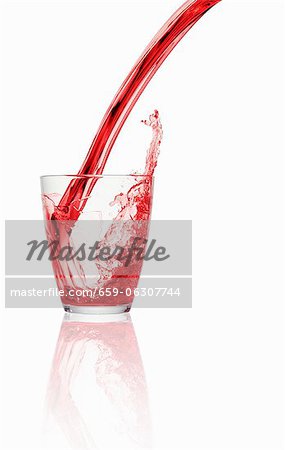 Ein roter kohlensäurehaltige Getränk in ein Glas gegossen