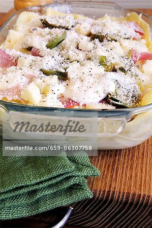 Unbaked lasagne with artichokes and ham in a baking dish