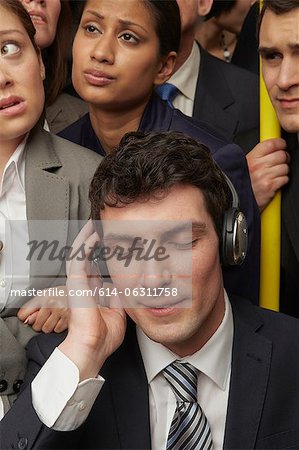 Businesswoman wearing headphones on subway train