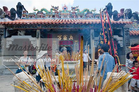 Worshipper offering incense at Pak Tai Temple during the Bun festival, Cheung Chau, Hong Kong
