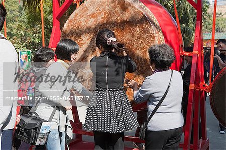 People beating drum for a wish during the Chinese New Year at Po Lin Monastery, Lantau Island, Hong Kong