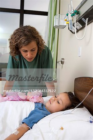 Infirmière réconfortante de petite fille malade à l'hôpital