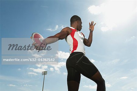 Male athlete throwing discus, low angle view